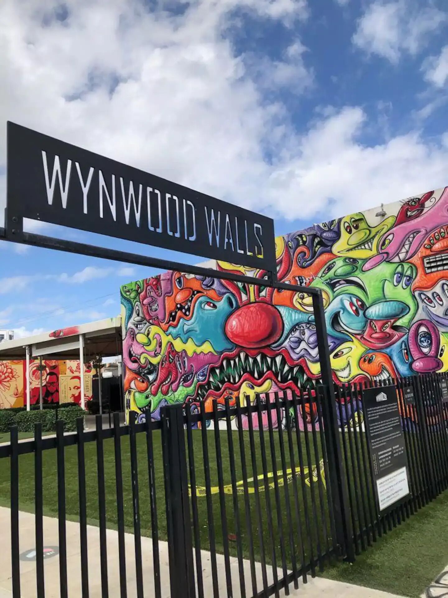 Wynwood Walls with a colorful mural and a black fence.