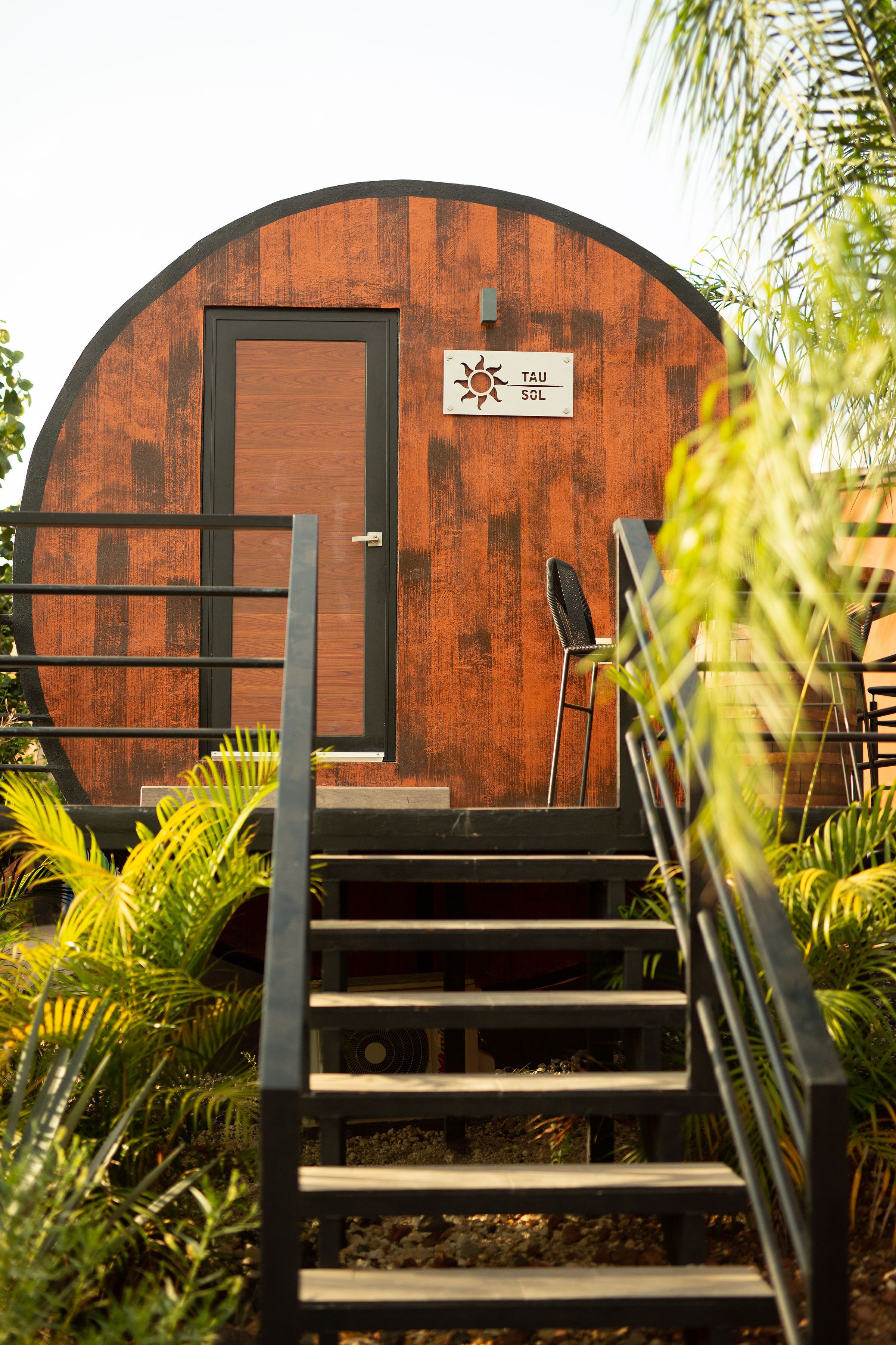 A wooden barrel-shaped building with a sign reading "TAU SGL".