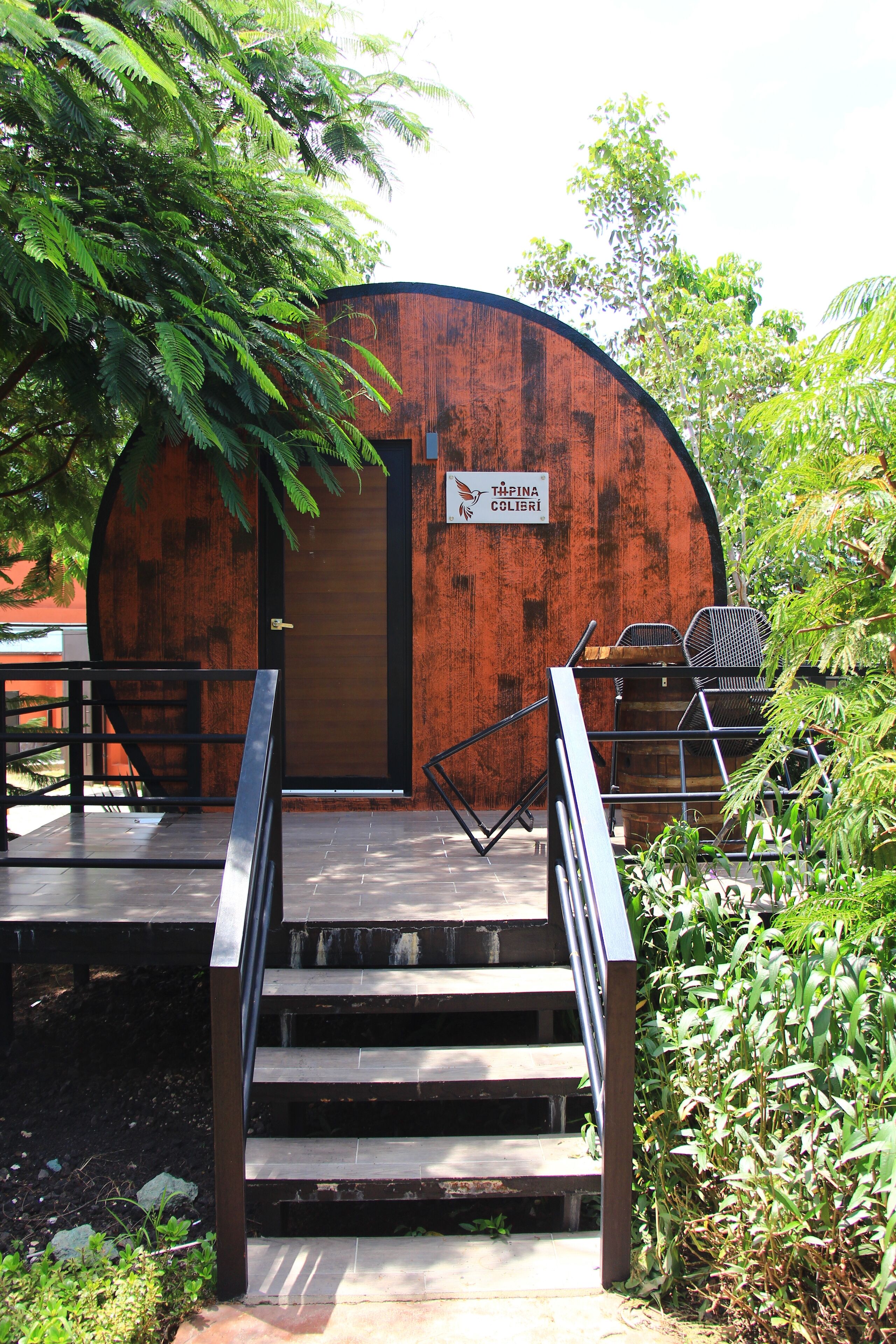 Un bâtiment en bois sur lequel est apposée une enseigne indiquant « Tafina Colibri ».
