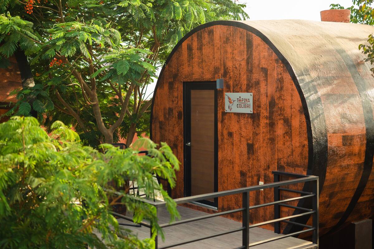 Un bâtiment en forme de tonneau, fait de bois, sur lequel on peut lire l’inscription « THIPIN COLIBRI ».