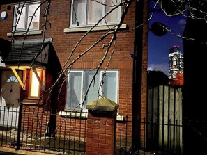 Stunning city views from this charming home with a brick facade, black metal fence, and inviting front door.