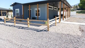 A small, single-story building with a covered porch and a gravel driveway. - Mini Cottage Rentals, Monroe UT. Come Ride the trails (Monroe)