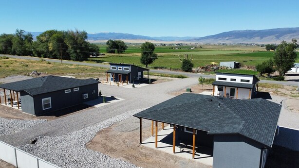 A rural property with multiple buildings, including a main house with a large deck and a smaller shed. - Mini Cottage Rentals, Monroe UT. Come Ride the trails (Monroe)