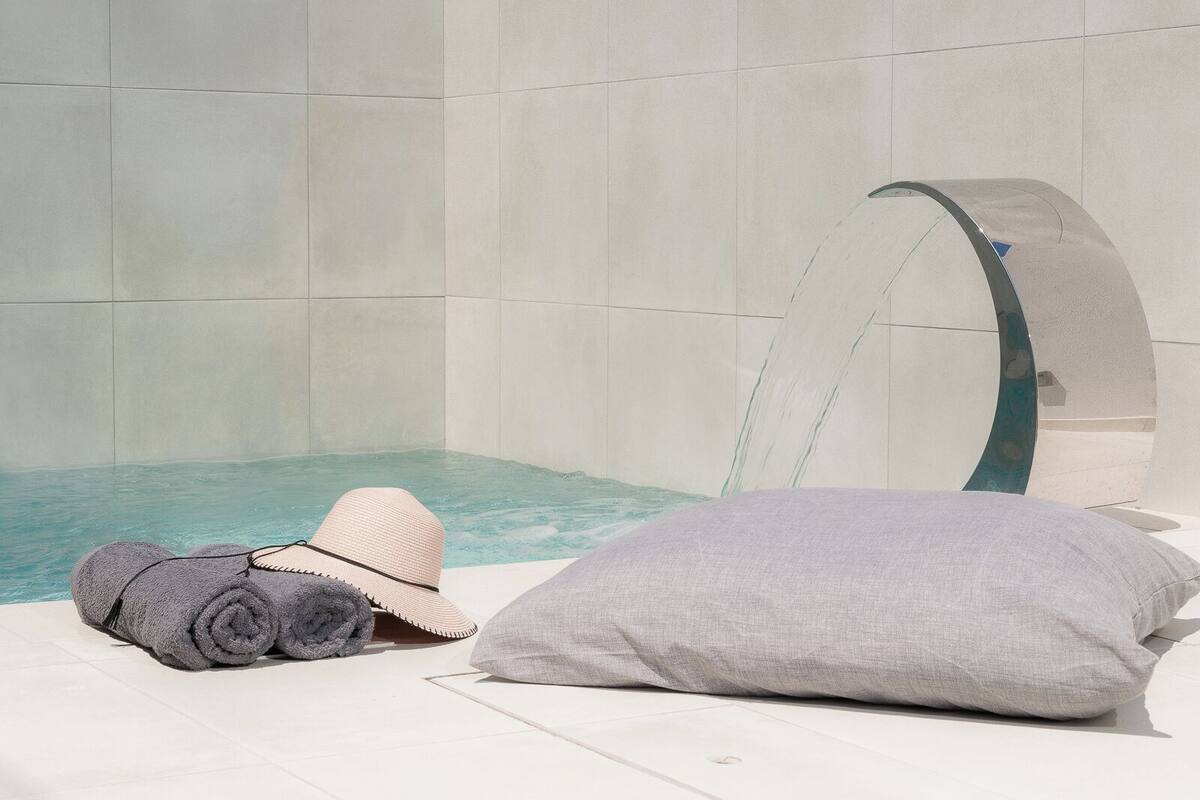 A spa area with a hot tub, towels, and a lounge chair.