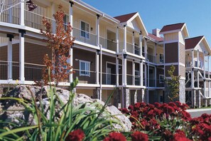 Stunning hotel with symmetrical design, featuring balconies and landscaped gardens.
