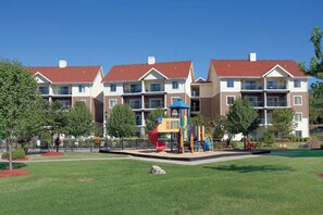 Stroll through the beautifully manicured grounds, featuring a playground with a slide and climbing elements.