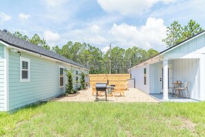 Un petit bâtiment d’un seul étage, doté d’un espace extérieur abrité pour s’asseoir et d’une clôture en bois en arrière-plan.