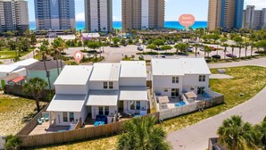 A beachfront property with multiple white buildings, a pool area, and a view of the ocean. - Welcome to Paradise! ~ STEPS to BEACH! ~ Sleeps 10 (Panama City Beach)