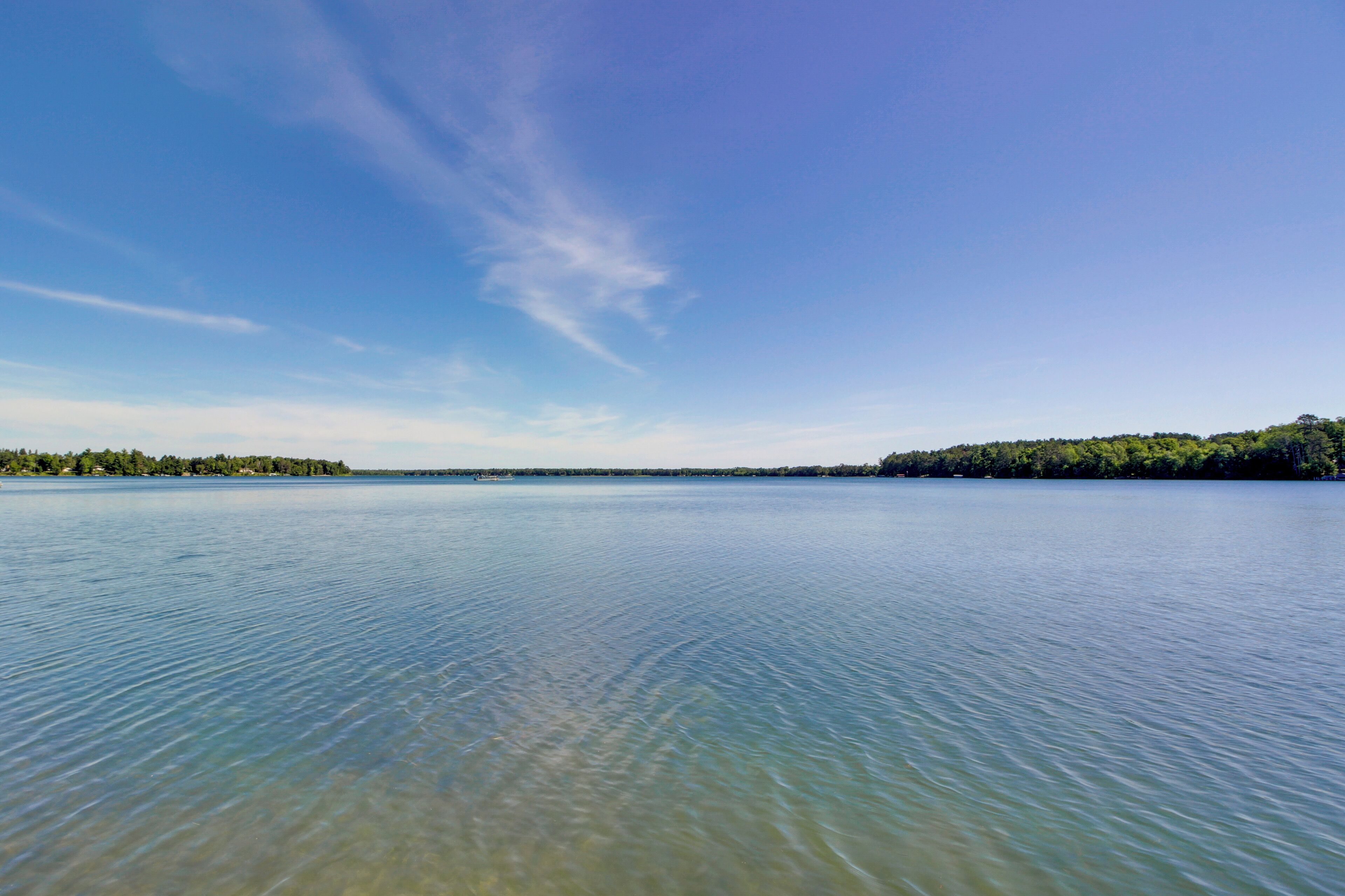 A calm lake with clear water and a distant shoreline.