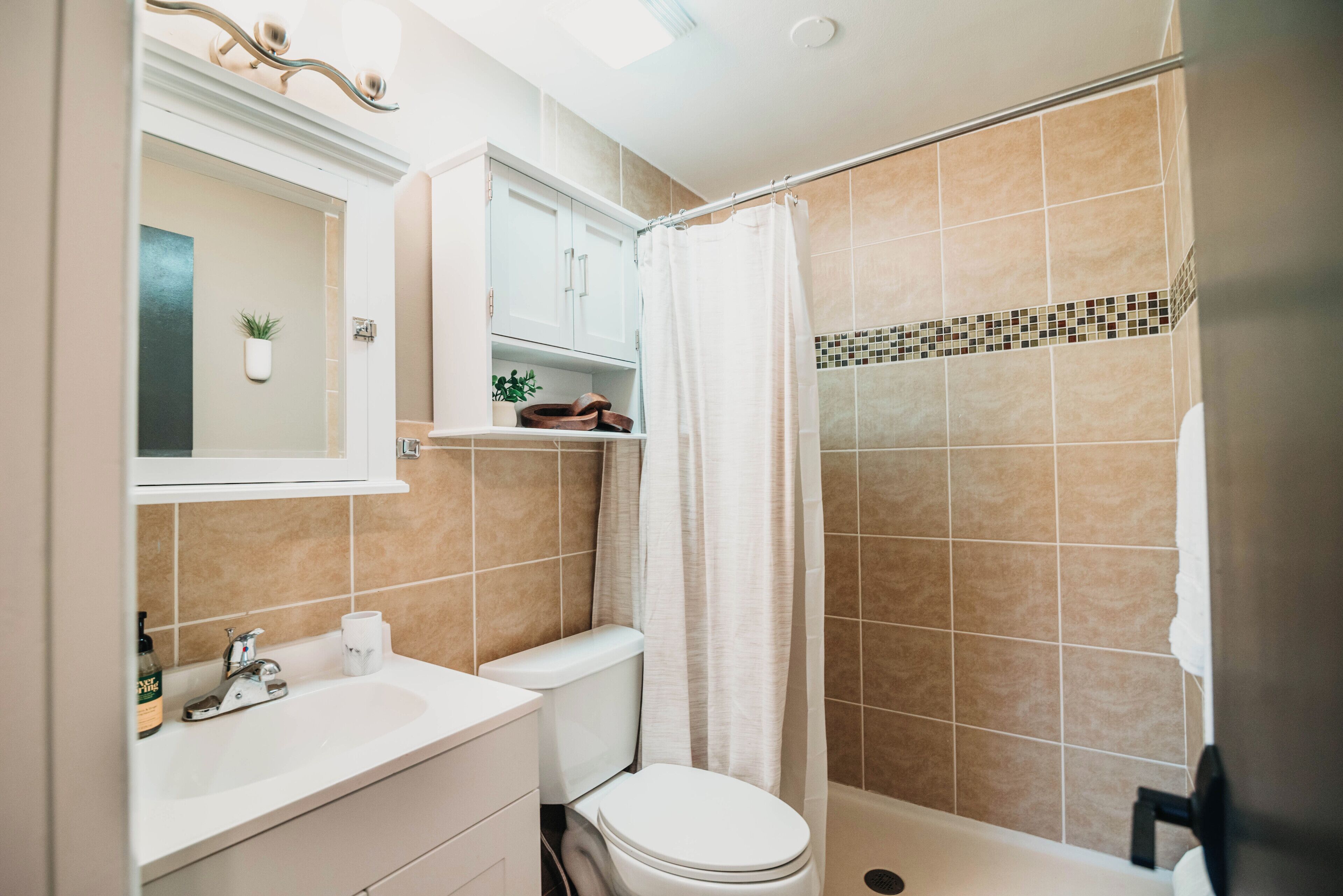 A bathroom with a toilet, sink, and shower area.