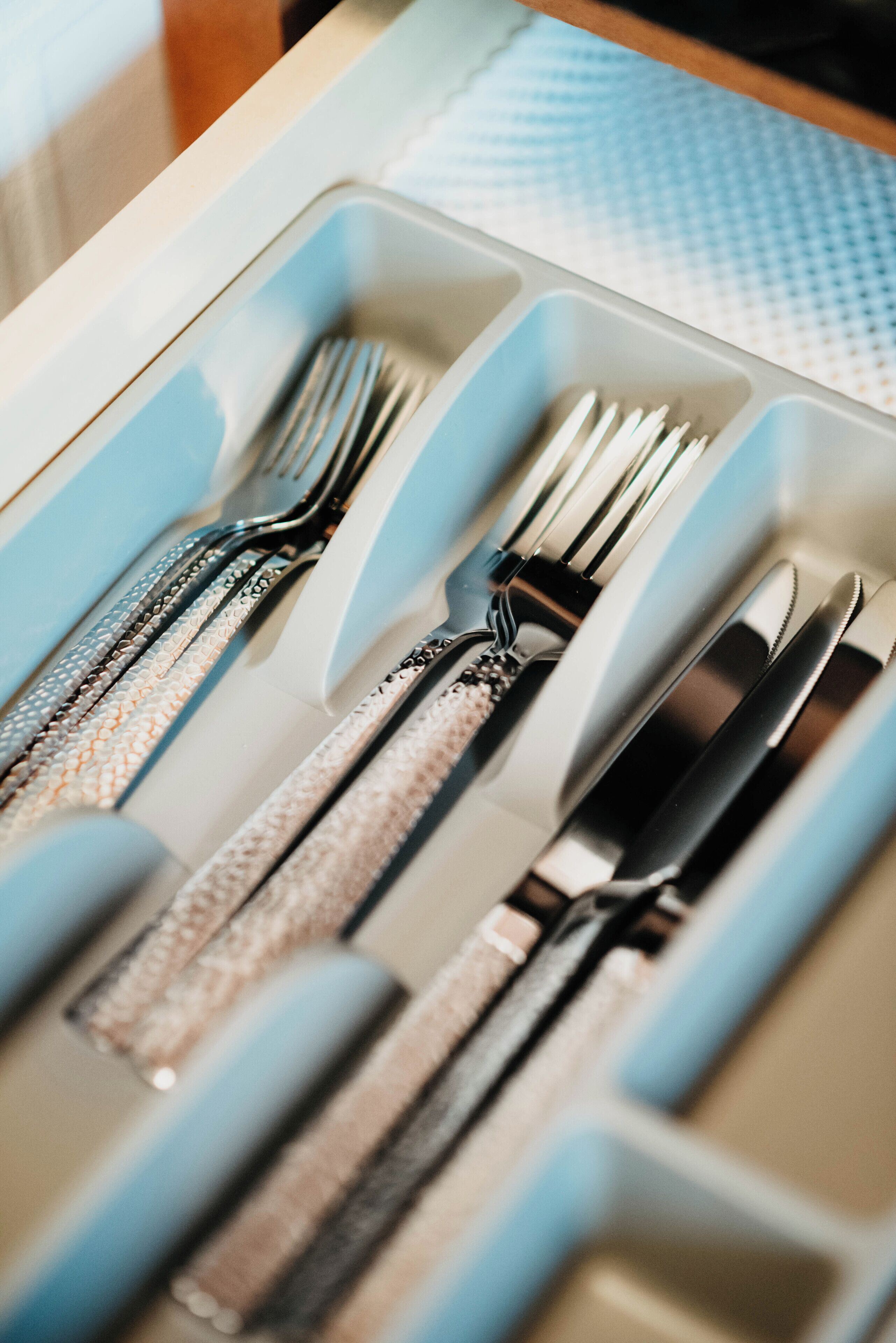 A drawer with utensils including forks, knives, and spoons.