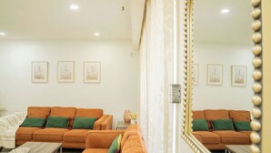 A living room with two sofas, a coffee table, and a large mirror.
