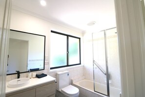 Un baño con lavamanos, inodoro y bañera.