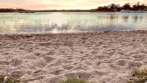 Uma praia com areal e águas calmas.