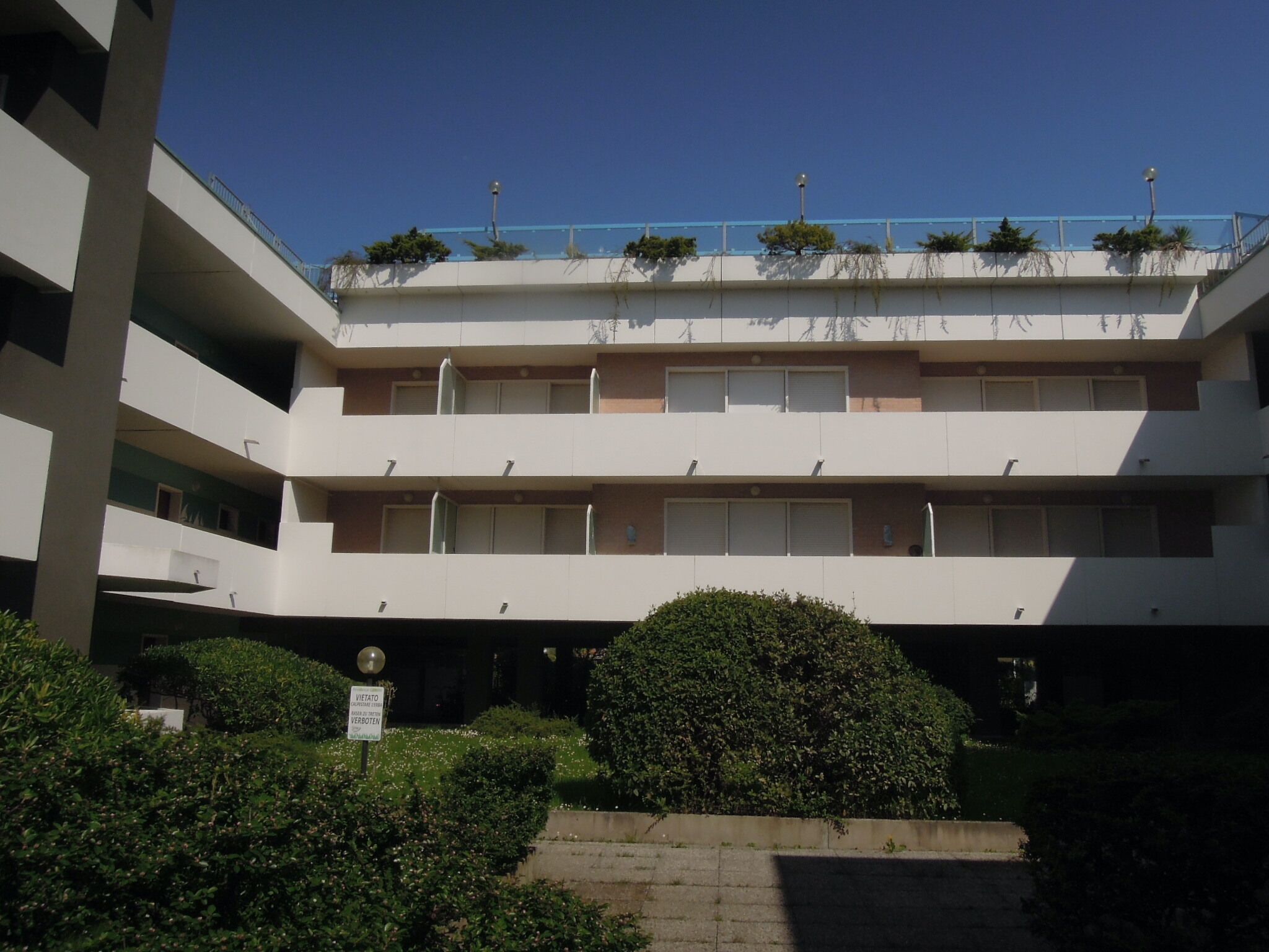 A multi-story building with a flat roof and balconies.