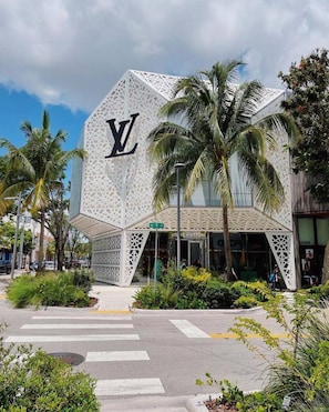 A Louis Vuitton store with a distinctive geometric facade and palm trees in the foreground. - Alloggio Wynwood Parking Laundry Wifi (Miami)