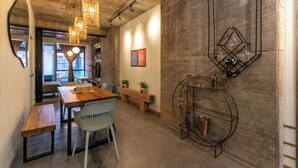 Un comedor moderno con una mesa de madera, sillas blancas e iluminación colgante.