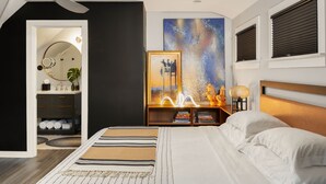 A modern bedroom with a bed, bedside tables, a ceiling fan, a painting, and a bookshelf. - Atlanta Pools and Palms Paradise (Atlanta)