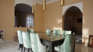 A dining room with a glass table, six chairs, and two hanging lamps. - Saphir Paon - Luxury Villa in the Middle of a Farm (Souihla)