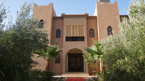 A building with a symmetrical facade, arched windows, and a central entrance with a decorative door. - Saphir Paon - Luxury Villa in the Middle of a Farm (Souihla)