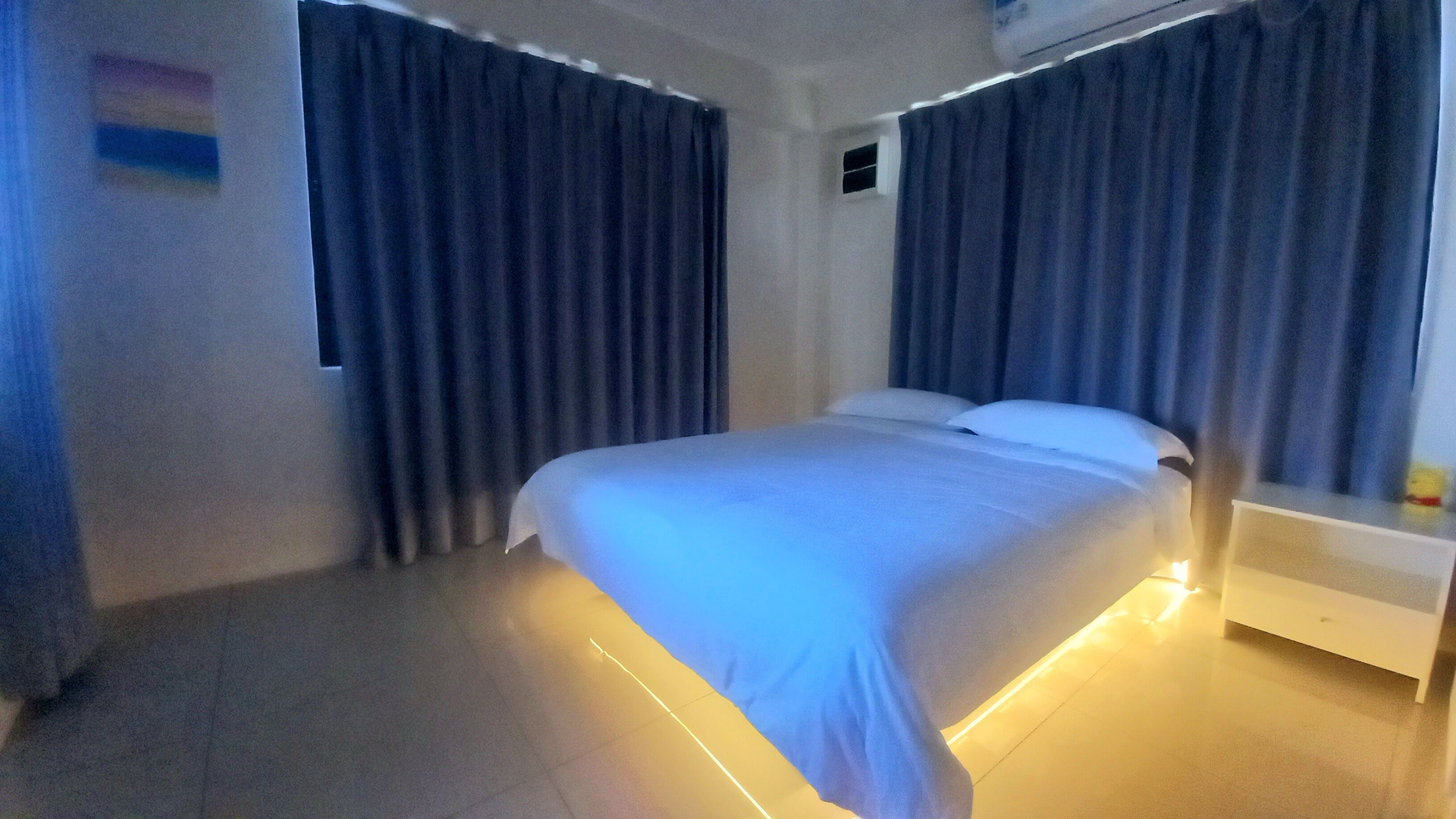 Ein Schlafzimmer mit Bett, Vorhängen und Nachttisch.
