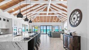 A spacious kitchen with a large island, white cabinetry, and a view to the outside.