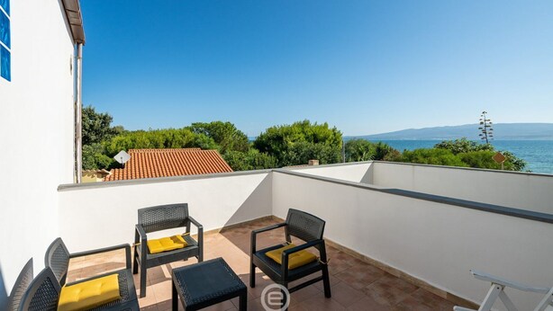 A rooftop terrace with outdoor furniture and a view of the sea. - La Casa sul Mare (Su Pallosu)