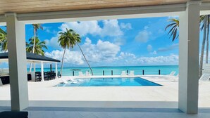 A pool area with lounge chairs and a view of the ocean. - KPOW on the Beach - Brand New 5 bedroom Luxury Beachfront House! (Steventon)