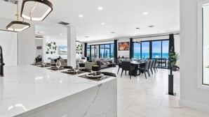 A spacious, modern kitchen with a marble countertop and pendant lighting. - KPOW on the Beach - Brand New 5 bedroom Luxury Beachfront House! (Steventon)