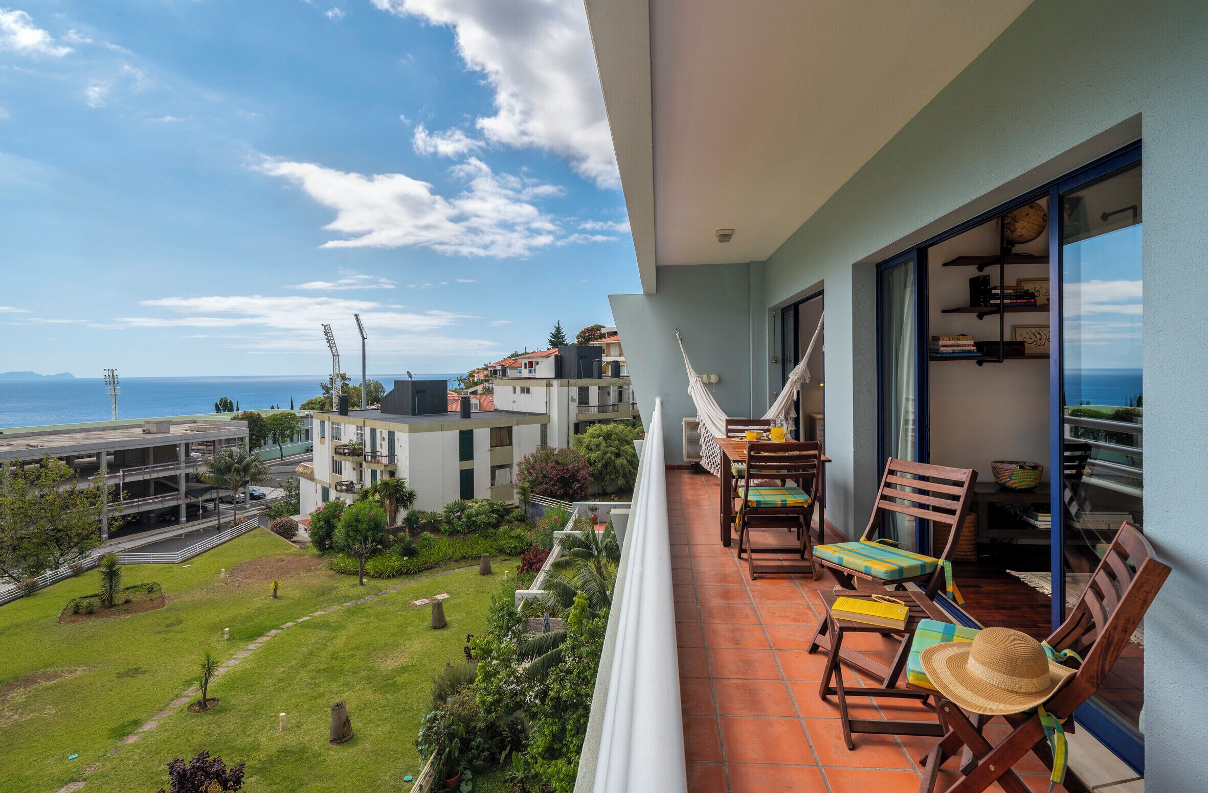 Un balcon avec vue sur la mer, un hamac et du mobilier d’extérieur.