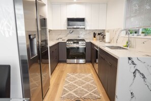 A compact kitchen with a built-in oven, microwave, and stainless steel appliances.