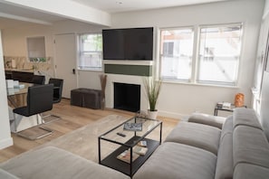 A modern living room with a sofa, coffee table, and a fireplace.