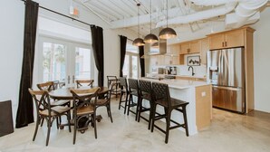A modern kitchen with wooden cabinets, a stainless steel refrigerator, and pendant lighting. - Palm Paradise Unique Home! WALK TO BEACH! 4 POOLS! (Panama City Beach)