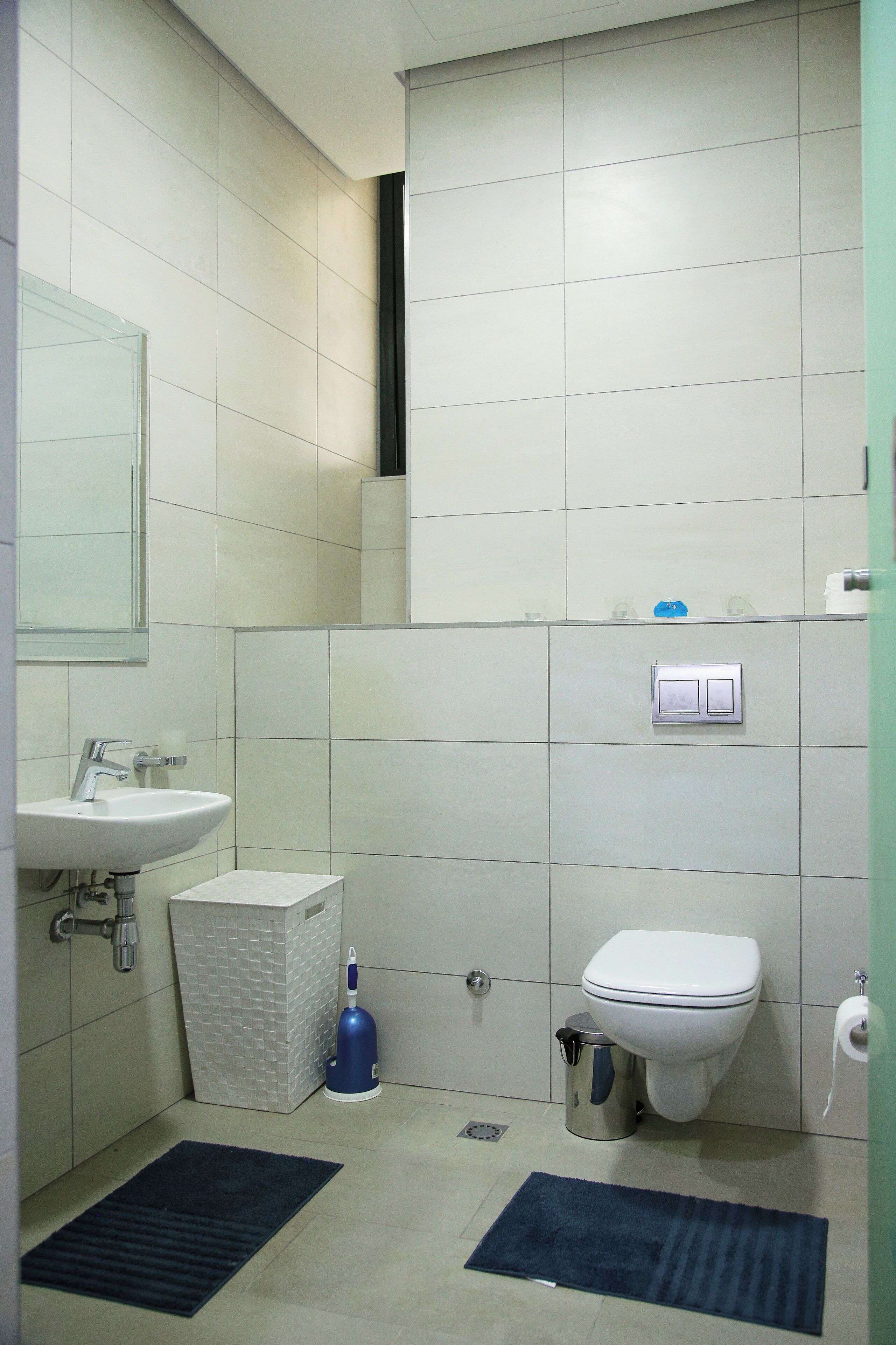 Een kleine, schone badkamer met een wastafel, toilet en spiegel.