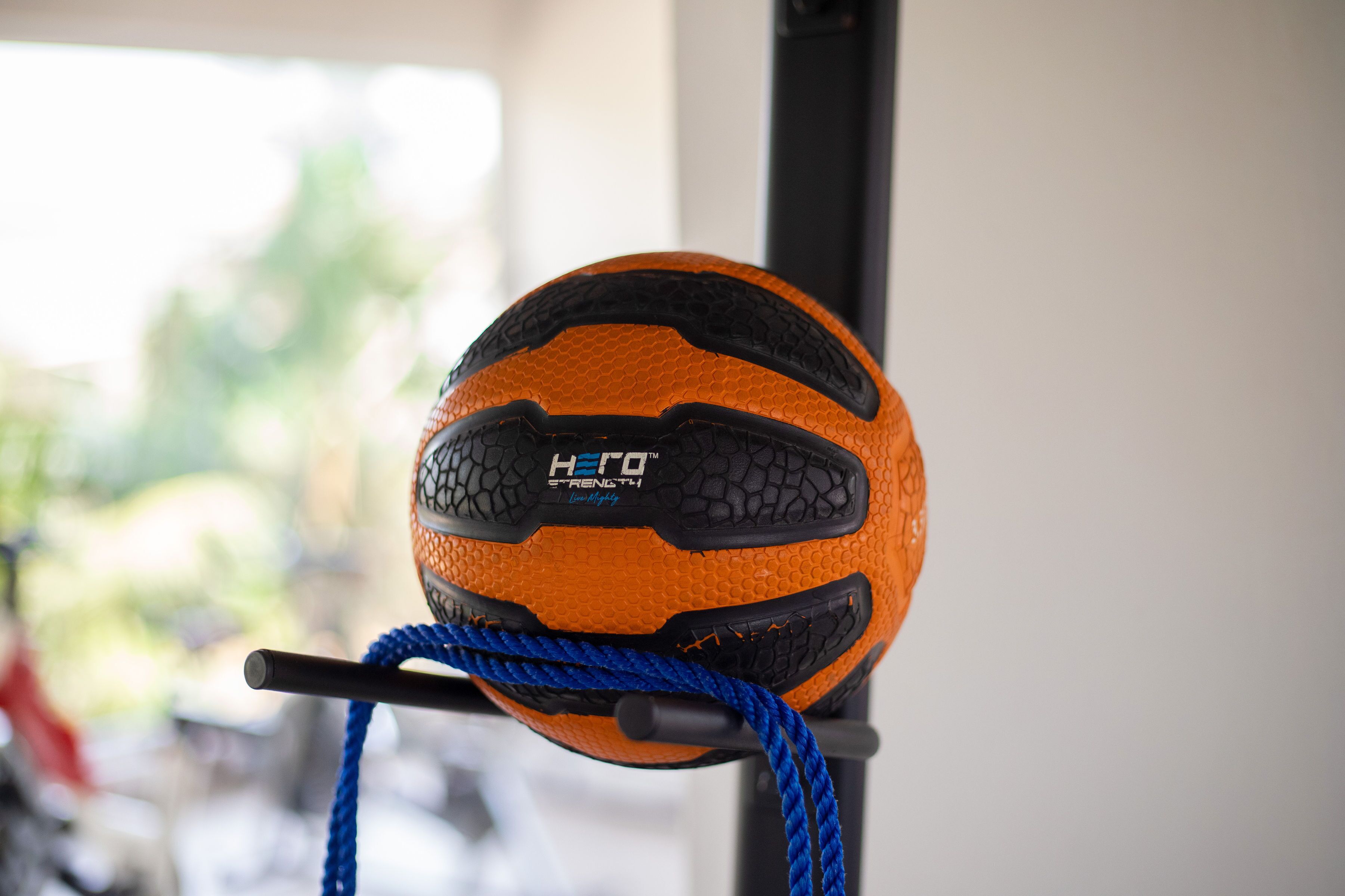 A gym ball with the text "Hero Strength" attached to a blue rope.