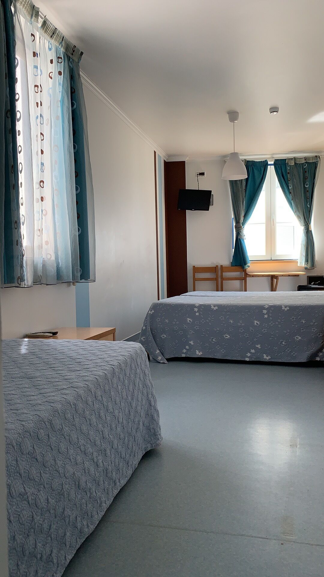 Una habitación con dos camas, un escritorio y una silla.