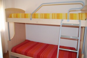 Un lit superposé avec un matelas à rayures et une échelle.