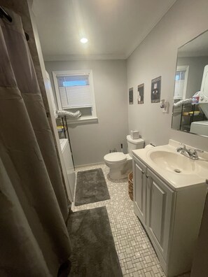 Un baño con inodoro, lavabo y ventana.