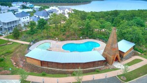 Un complexe hôtelier doté d’une piscine, d’une structure en bois et offrant une vue sur un lac.