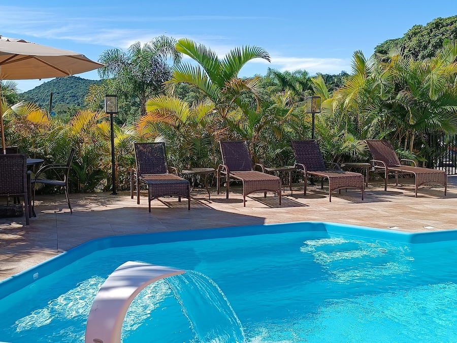 Una piscina al aire libre, sombrillas, sillones reclinables de piscina