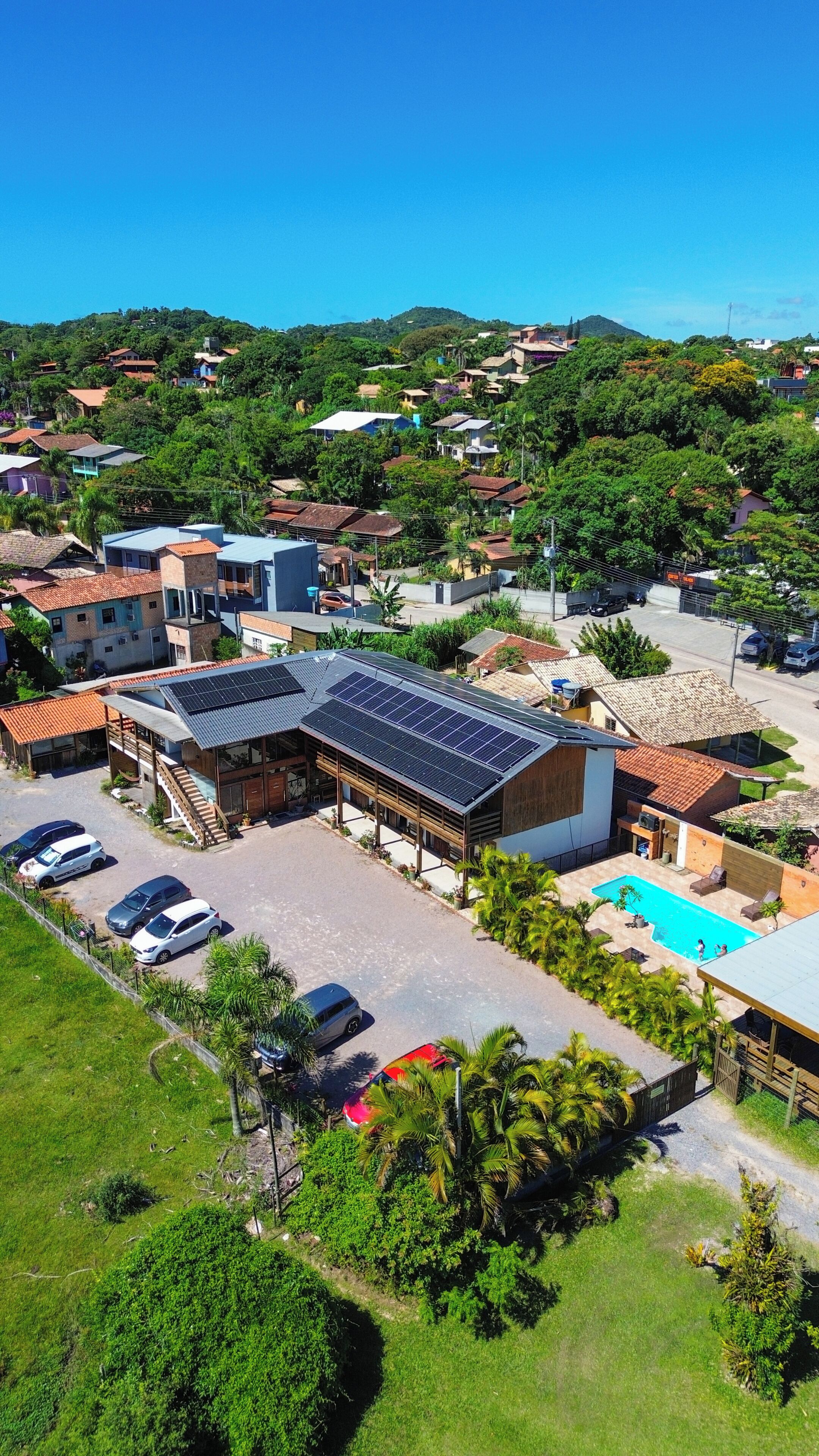 Zona residencial con casas, piscina y un edificio con paneles solares.
