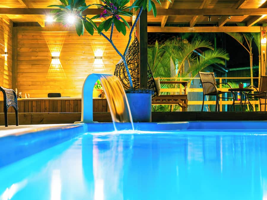 Una piscina al aire libre, sombrillas, sillones reclinables de piscina