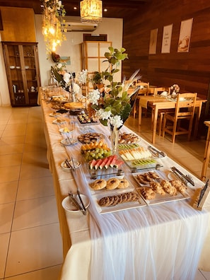 Une table de buffet garnie de divers plats, un mur en bois et un luminaire suspendu.