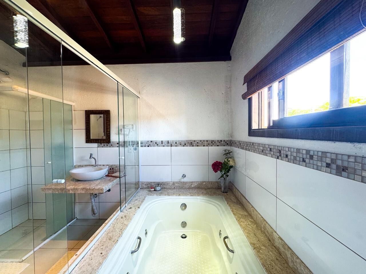 A modern bathroom with a glass-enclosed shower, a freestanding bathtub, and a vanity with a sink.