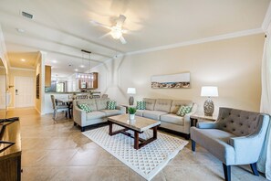 A spacious living room with a sofa, armchair, coffee table, and a dining area in the background. - Bonita Springs Condo Rental w/ 2 Screened Porches (Bonita Springs)