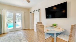 A dining area with wicker chairs, a round table, and a ceiling fan. - Cozy Ocala Retreat w/ Pool, Screened Lanai! (Ocala)