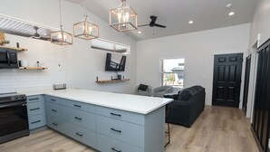 A modern kitchen with a central island, built-in appliances, and pendant lighting.