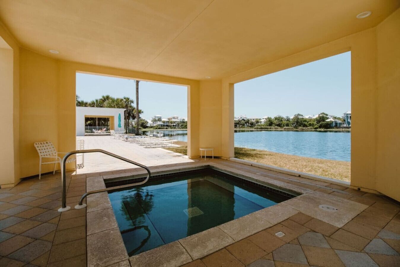 A swimming pool with a clear view of the lake and surrounding buildings.