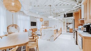 Une cuisine moderne avec des meubles en bois, un îlot en marbre et des luminaires suspendus.