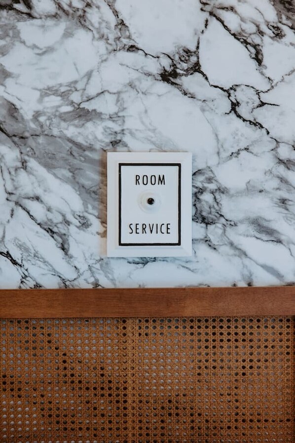Une pancarte encadrée avec l’inscription « SERVICE EN CHAMBRE » posée sur un sol en marbre.